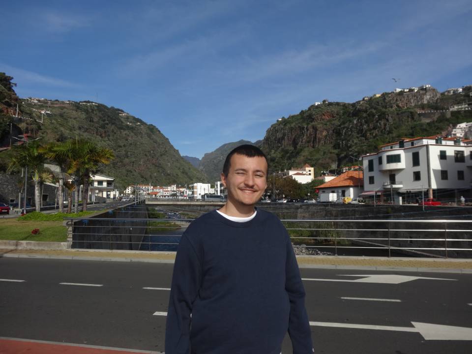 Mateo standing on a street with mountains in the background